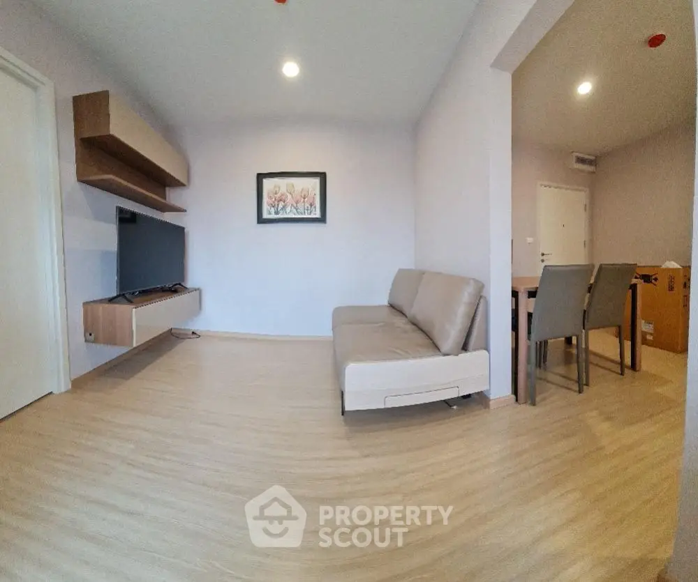 Modern living room with sleek furniture and wall-mounted TV in a stylish apartment.