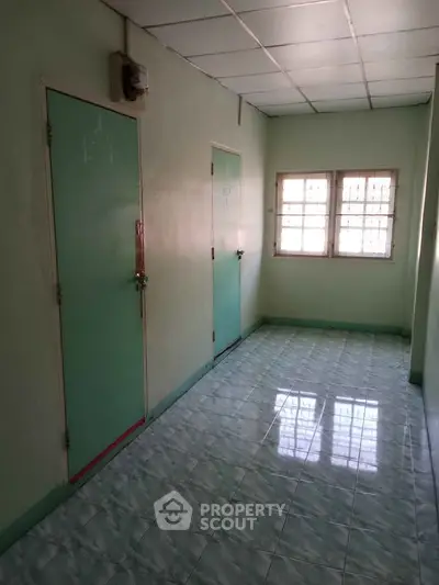 Simple hallway with tiled floor and two doors in residential property