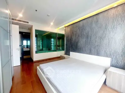 Modern bedroom with stylish accent wall and wooden flooring in luxury apartment