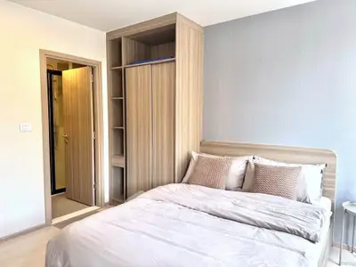 Modern bedroom with built-in wardrobe and cozy bedding in a stylish apartment.