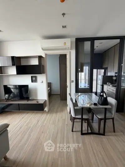 Modern open-plan living room with dining area and kitchen in stylish apartment.
