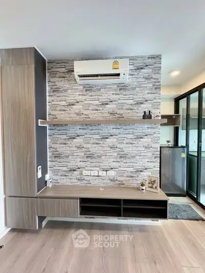Modern living room with stylish stone accent wall and air conditioning unit.