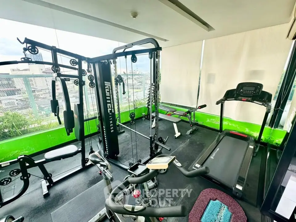 Modern gym with state-of-the-art equipment and panoramic city views, perfect for fitness enthusiasts.
