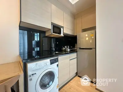 Modern kitchen with sleek appliances and wooden cabinetry in a stylish apartment.