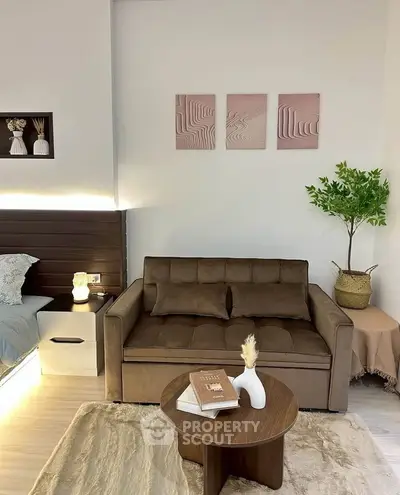 Cozy living room with modern decor, featuring a plush brown sofa, stylish coffee table, and elegant wall art.