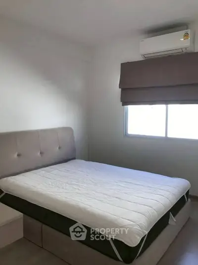Cozy bedroom with modern air conditioning and natural light, perfect for relaxation.