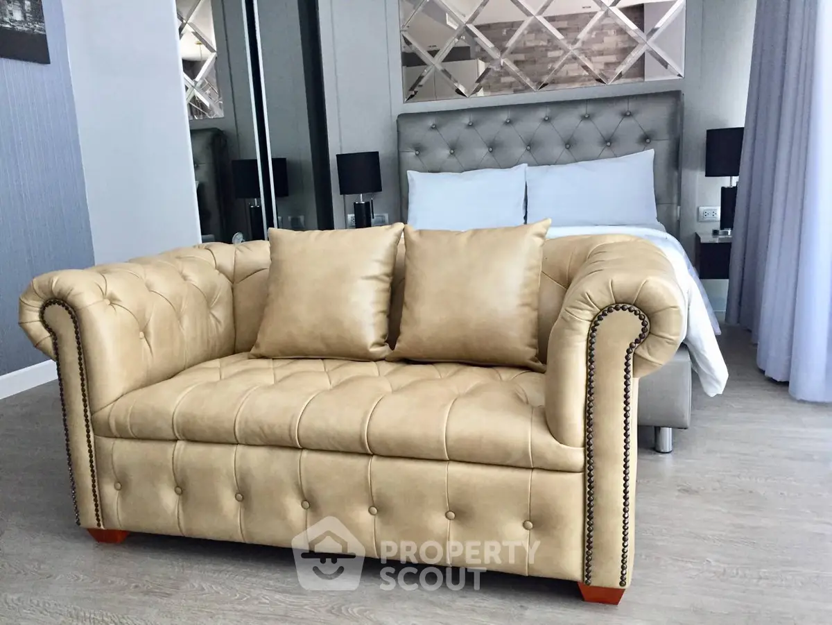 Luxurious bedroom with elegant beige sofa and plush bed