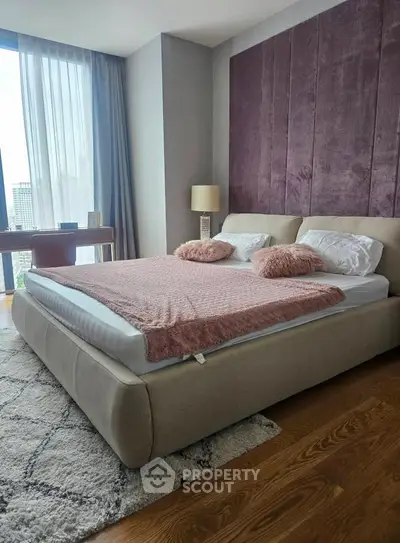 Luxurious bedroom with plush bed and city view, perfect for modern living.