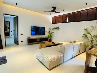 Modern living room with sleek furniture and large TV, perfect for relaxation and entertainment.