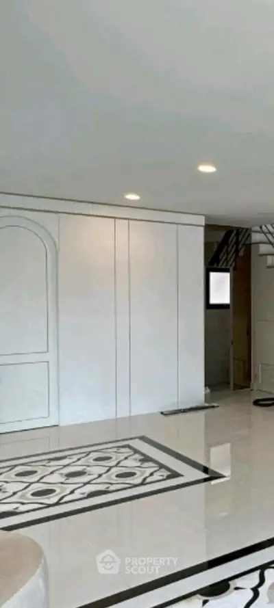 Spacious modern interior with elegant tile flooring and stylish staircase, perfect for luxury living.