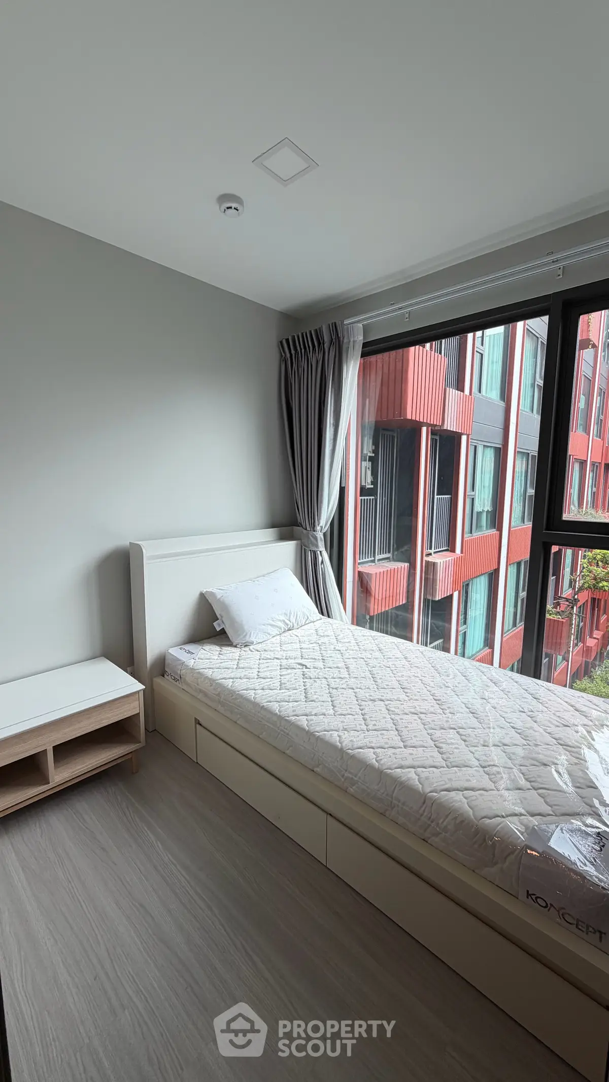 Modern bedroom with large window and minimalist decor in urban apartment