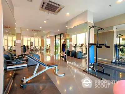 Spacious modern gym with state-of-the-art fitness equipment and mirrored walls in luxury real estate property.