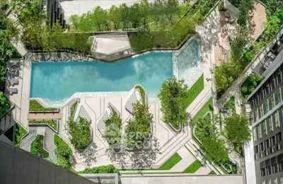 Luxurious aerial view of modern apartment complex with stunning pool and lush greenery.