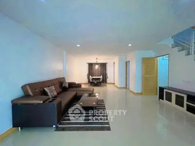 Spacious living room with modern furniture and elegant dining area in open layout.