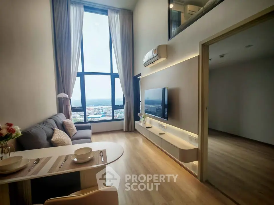 Modern high-ceiling living room with large windows and stylish decor