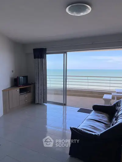 Spacious living room with stunning ocean view and balcony access.