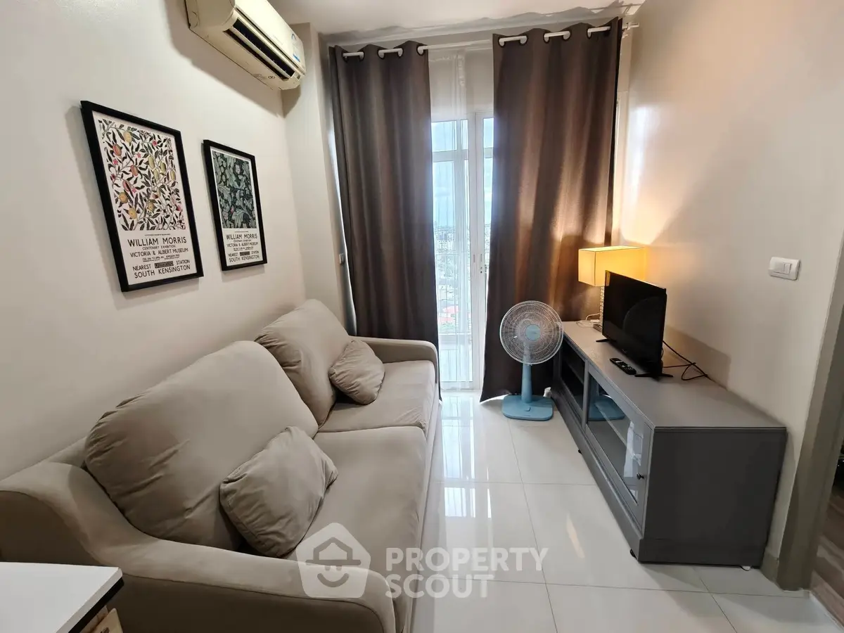 Cozy living room with modern decor, featuring a comfortable sofa and a large window with curtains.