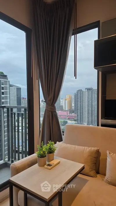 Modern living room with city view, featuring cozy sofa and elegant curtains in a high-rise apartment.