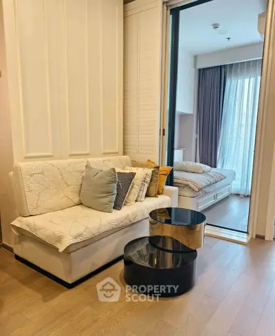Modern apartment interior with cozy living area and bedroom, featuring stylish furniture and natural light.