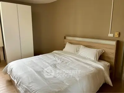 Cozy bedroom with modern wooden bed and white wardrobe, perfect for relaxation.