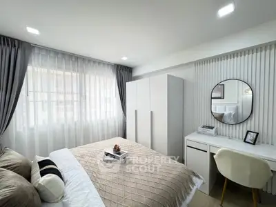 Modern bedroom with stylish decor, featuring a cozy bed, sleek wardrobe, and elegant study area.