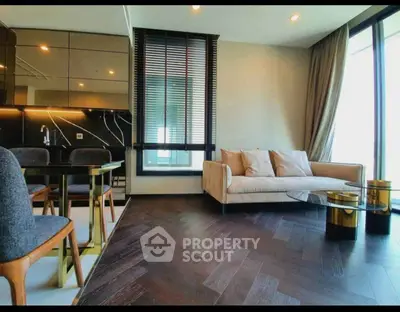 Luxurious modern living room with elegant furniture and large windows offering natural light.