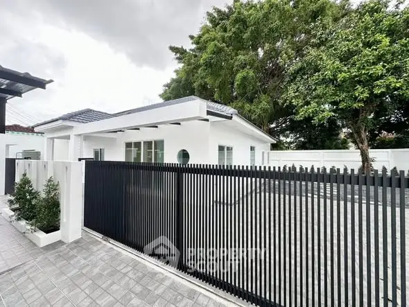 Modern white house with sleek black fence and spacious driveway