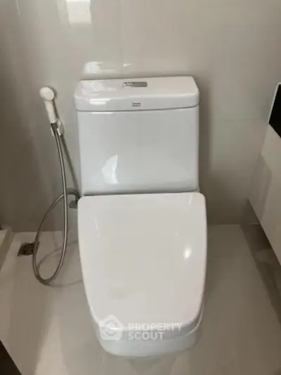 Modern bathroom with sleek toilet design and bidet spray