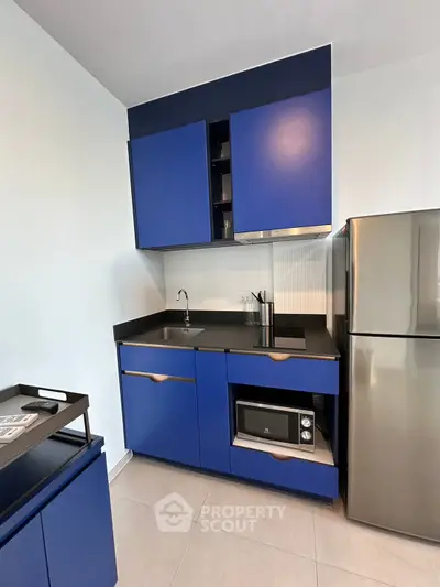 Modern kitchen with sleek blue cabinets and stainless steel appliances