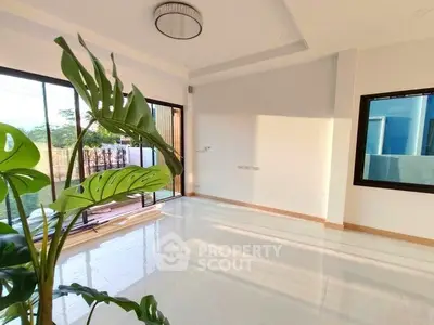 Spacious living room with large windows and modern lighting, perfect for natural light lovers.