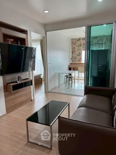 Modern living room with sleek furniture and open layout leading to a stylish dining area.