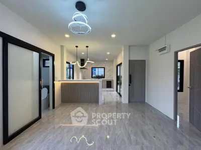 Modern open-plan living area with sleek kitchen and stylish lighting fixtures.