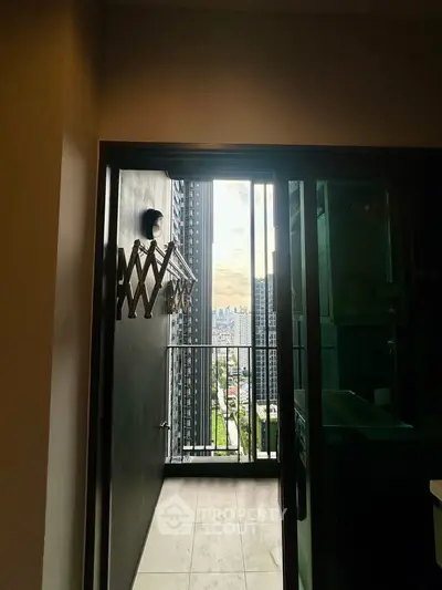 Modern apartment balcony with stunning city view and laundry rack.