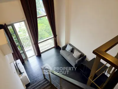 Modern loft apartment with high ceilings and large windows offering a stunning view.