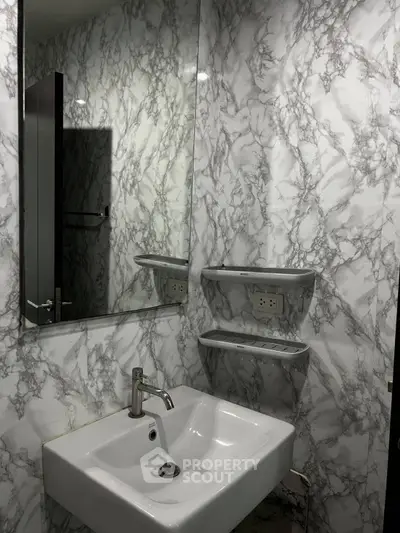 Modern bathroom with marble-patterned walls and sleek white sink