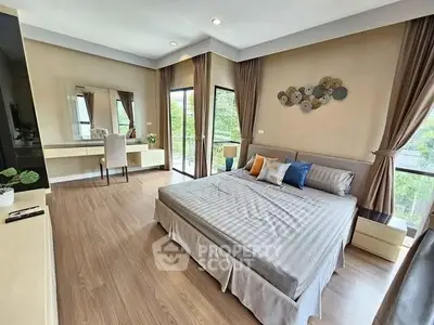 Spacious modern bedroom with elegant decor and large windows offering natural light.
