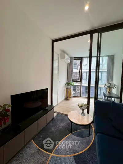 Modern living room with sleek furniture and large windows offering natural light.