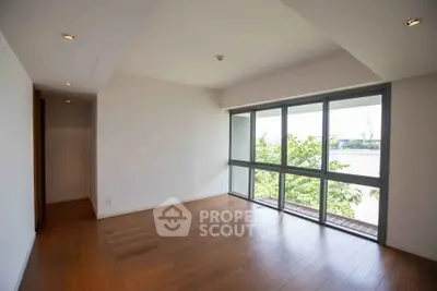 Spacious empty room with large windows and river view