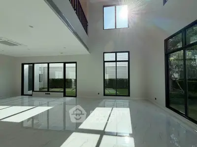 Spacious modern living room with high ceilings and large windows offering abundant natural light.