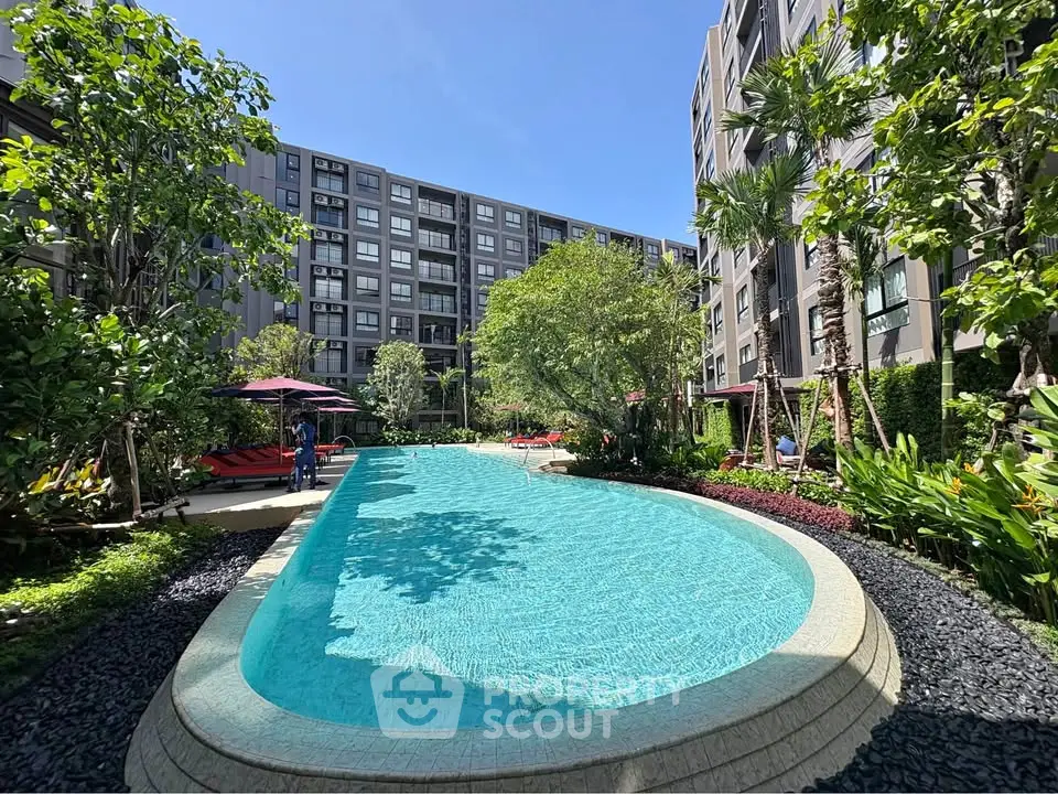 Luxurious apartment complex with a stunning outdoor pool and lush greenery.