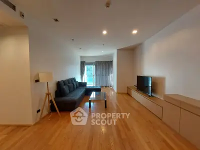 Spacious living room with modern furniture and wooden flooring, perfect for relaxation and entertainment.