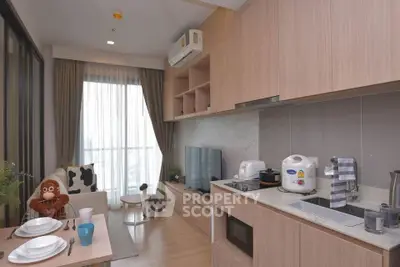 Modern kitchen and living area with stylish decor and appliances in a cozy apartment setting.
