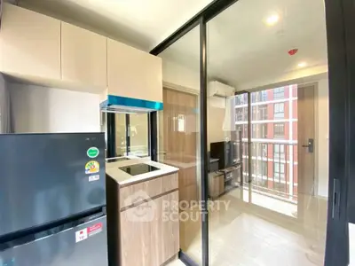 Modern kitchen with sleek appliances and balcony view in a stylish apartment.