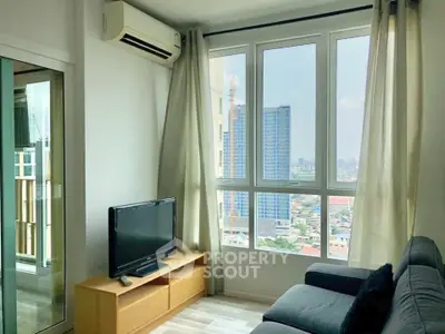 Bright living room with city view, featuring modern furniture and large windows.