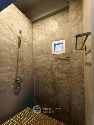 Modern minimalist bathroom with textured walls and small window