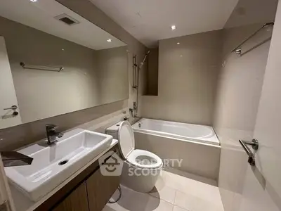 Modern bathroom with sleek fixtures and a bathtub in a contemporary apartment.