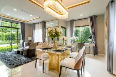 Luxurious open-plan living and dining area with elegant chandelier and garden view.