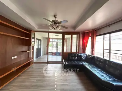 Spacious living room with leather sofa and built-in wooden shelves