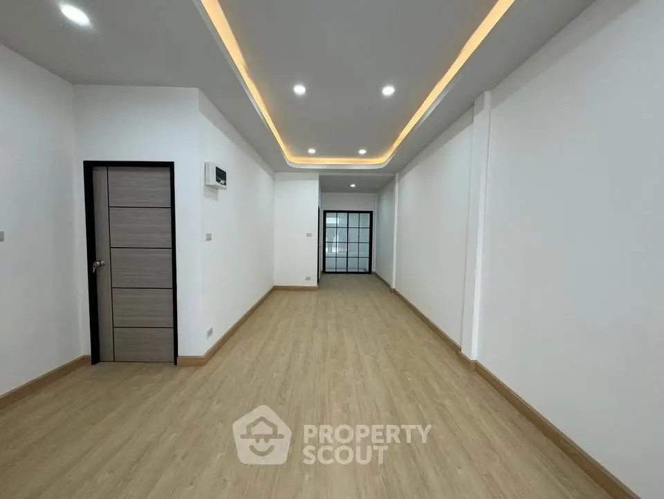 Spacious modern living room with recessed lighting and wooden flooring