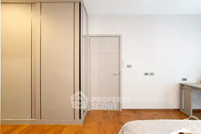 Modern bedroom with sleek wardrobe and wooden flooring